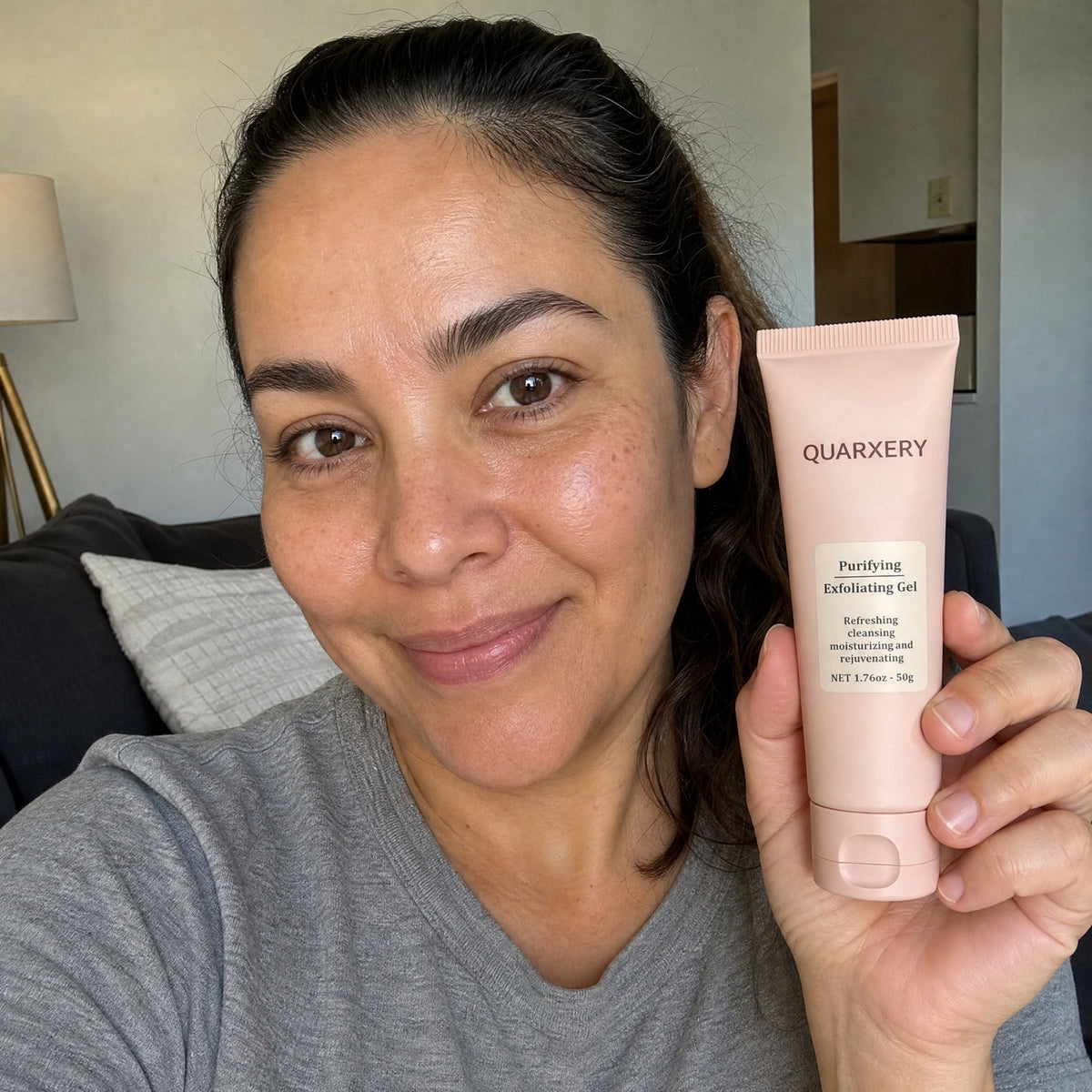 Mujer sosteniendo el tubo de Quarxery gel exfoliante en casa