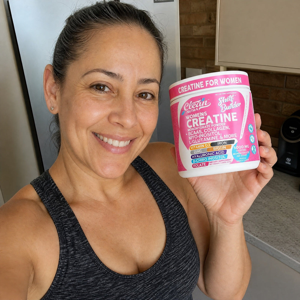 Mujer de 45 años con su frasco de creatina Shelf Builder en la cocina